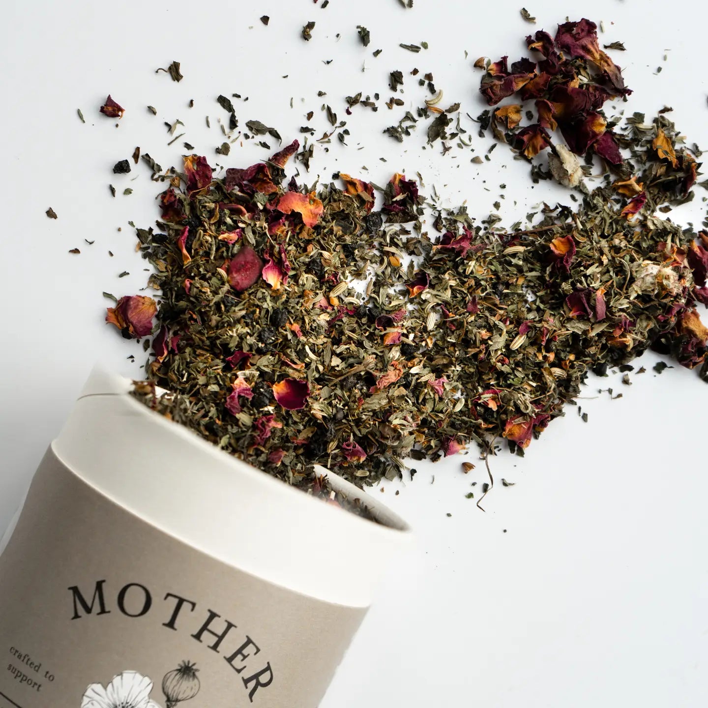 Spilled dried herbs from a 'MOTHER' branded container on a white background