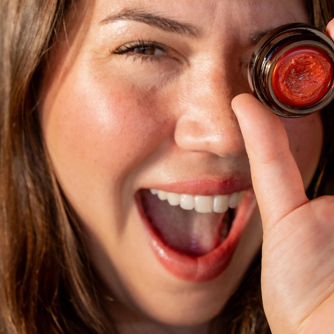Close-up of a woman using a red eye removal tool on a camera lens.